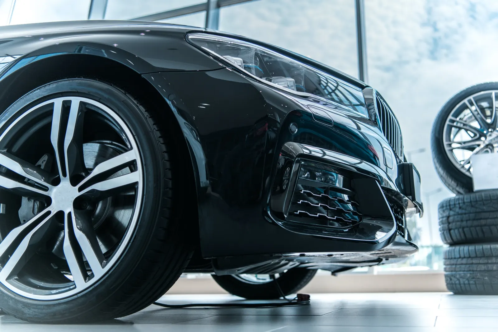 Autoturism nou expus într-un showroom, detaliu jantă și caroserie